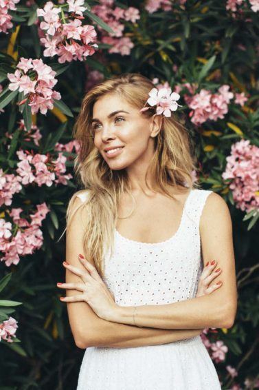 Mulher com cabelo solto e uma flor do lado mostra penteado para a primavera