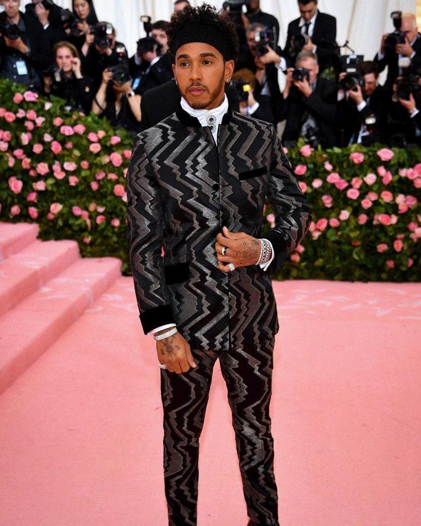 Piloto Lewis Hamilton com cabelo cacheado e faixa