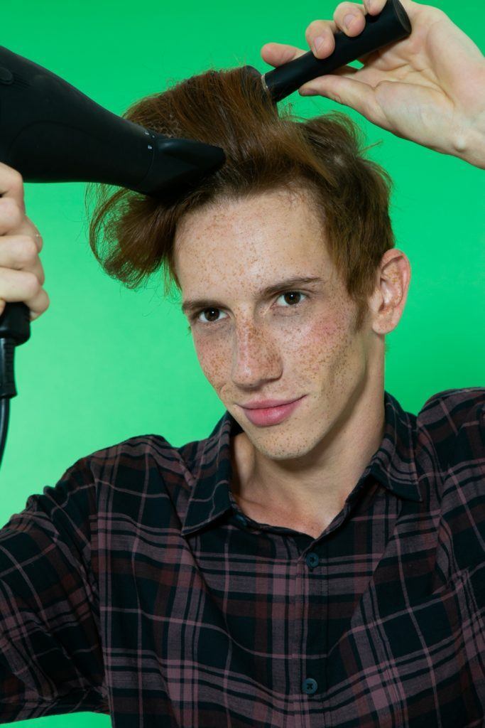 Modelo de cabelo ruivo escovando o cabelo