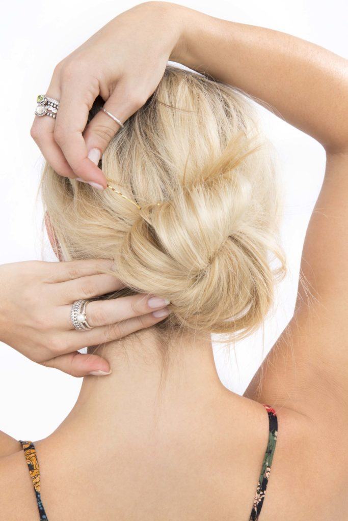 modelo usando um coque bagunçado para cabelo longo