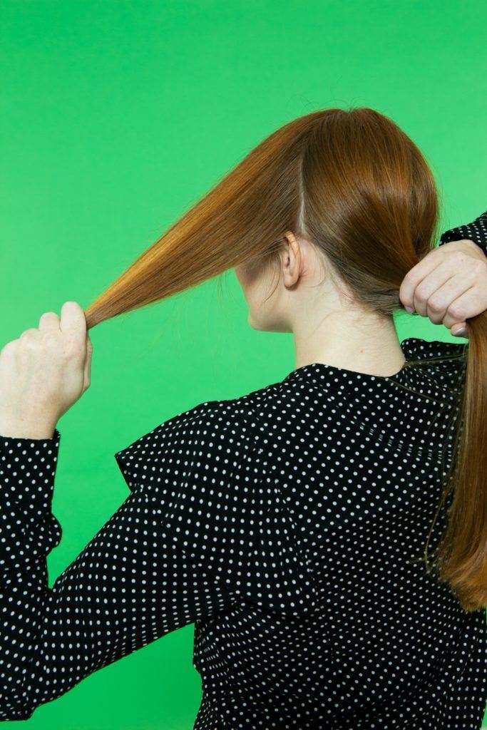 Modelo divide o cabelo no passo a passo para fazer coque chignon