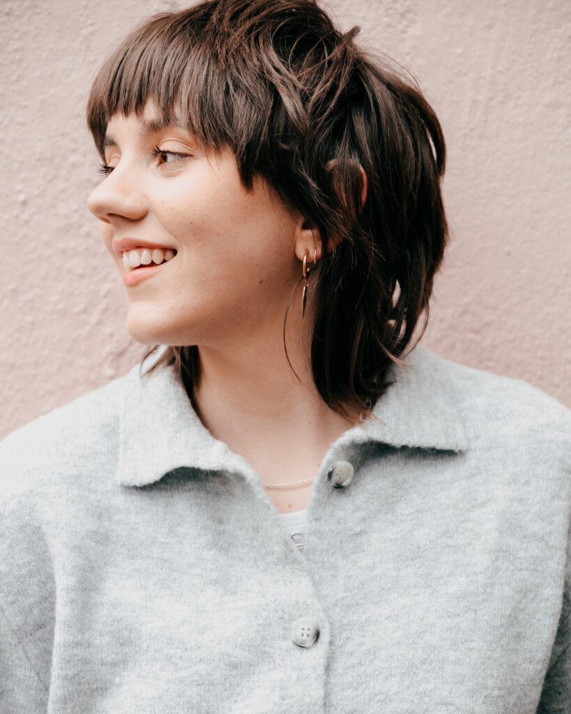 Mulher com corte de cabelo curto com franja repicada