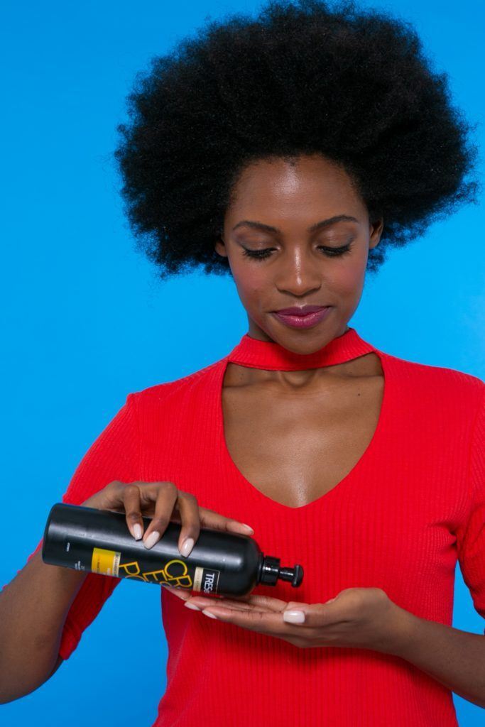 modelo de cabelo afro aplicando o Creme de Pentear TRESemmé Crespos