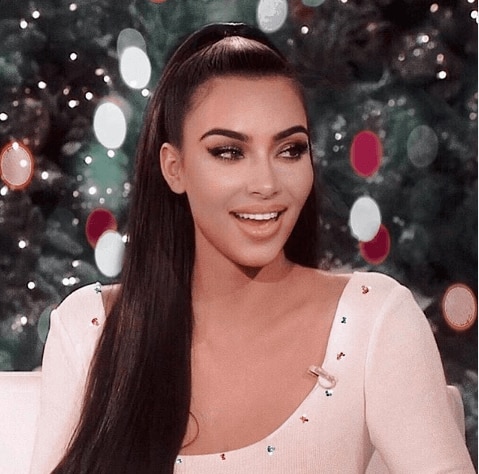 Mulher (Kim Kardashian) dá entrevista com cabelos lisos e escuros presos para o alto em rabo de cavalo