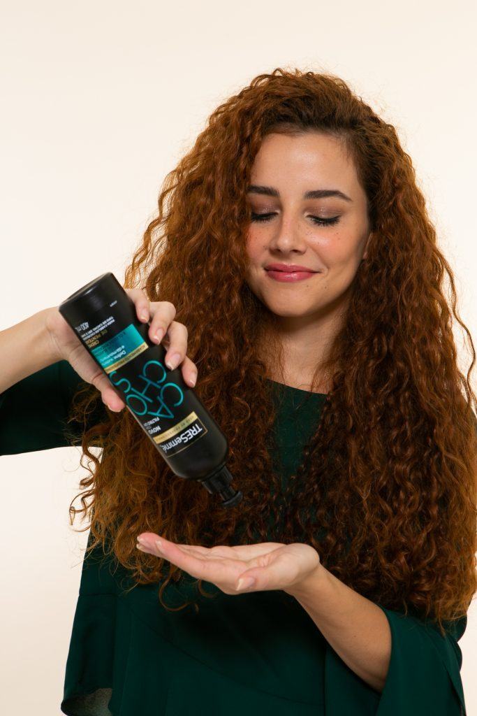 Modelo aplica creme de pentear