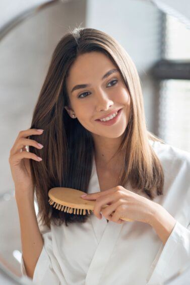mulher penteado o cabelo em frente ao espelho