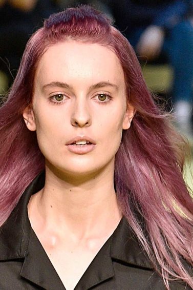 Mulher usa cabelo ruivo violeta, na passarela