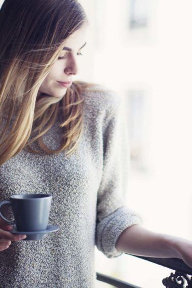 Mulher loira com xícara de café mostra segredos das mulheres impecáveis