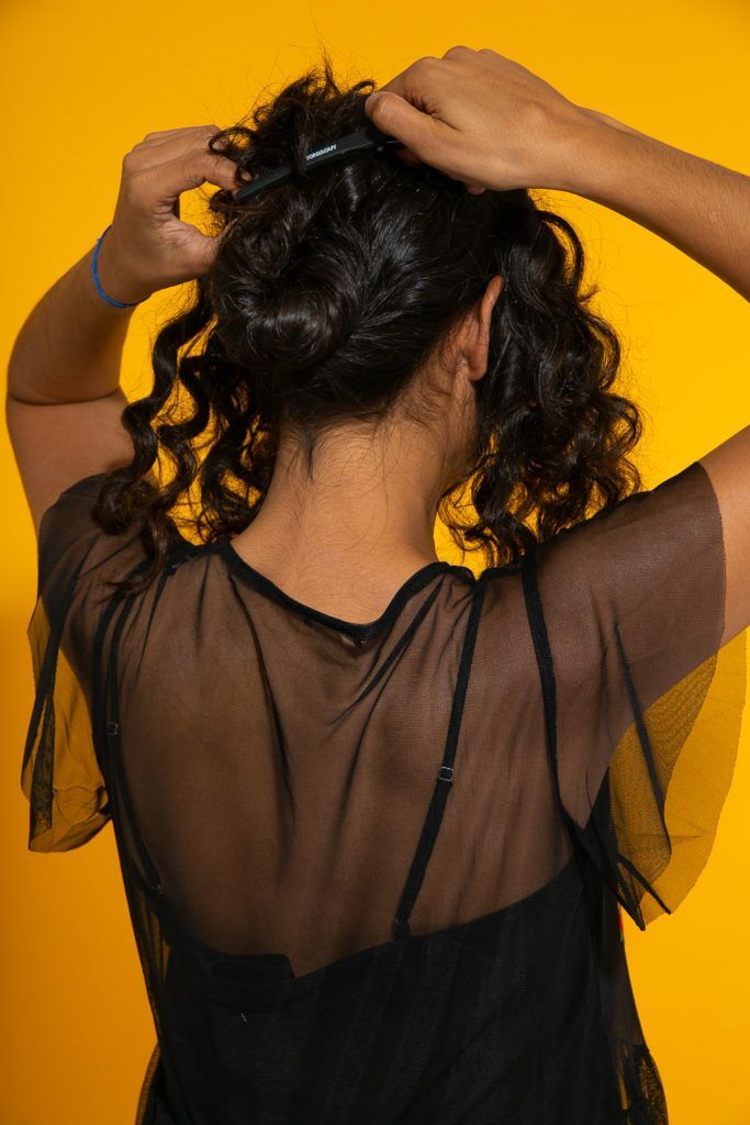 Cabelo cacheado preso para preparação do penteado