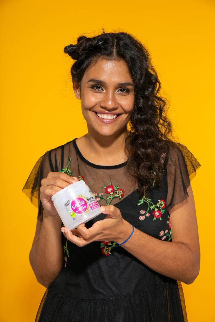 Aplicação de creme de pentear em cabelo cacheado