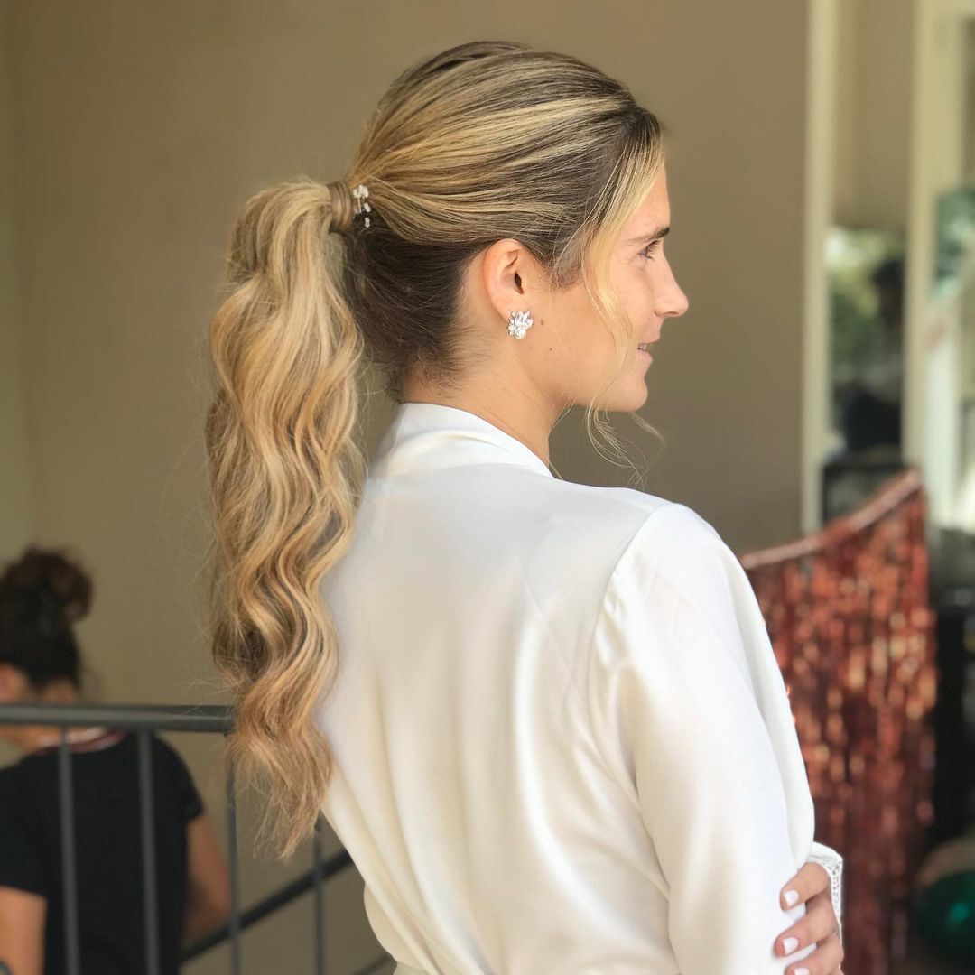 Mulher com cabelo preso em um rabo de cavalo que esconde o elástico com uma mecha de cabelo