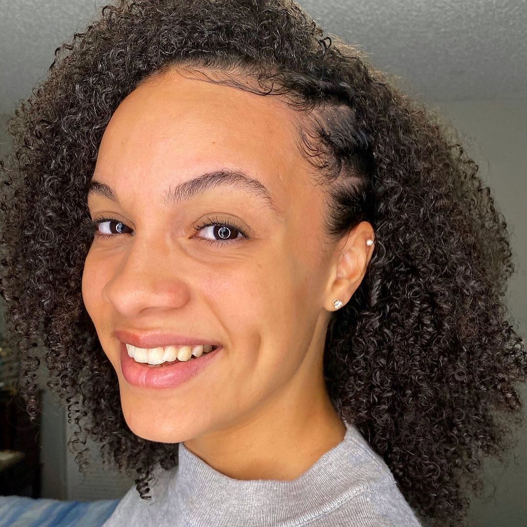 Mulher com torcidinho em mechas do cabelo cacheado