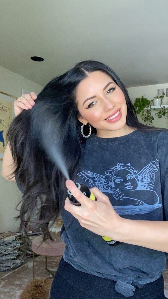 Justine Marjan borrifa shampoo a seco no comprimento