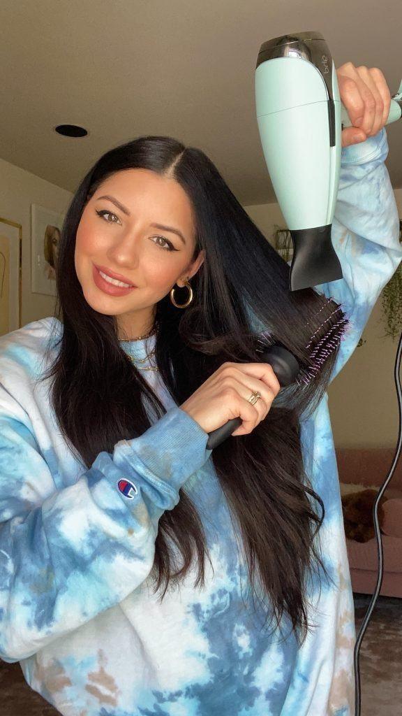 Justine Marjan seca o cabelo com uma escova redonda