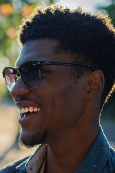 homem sorrindo de óculos escuros