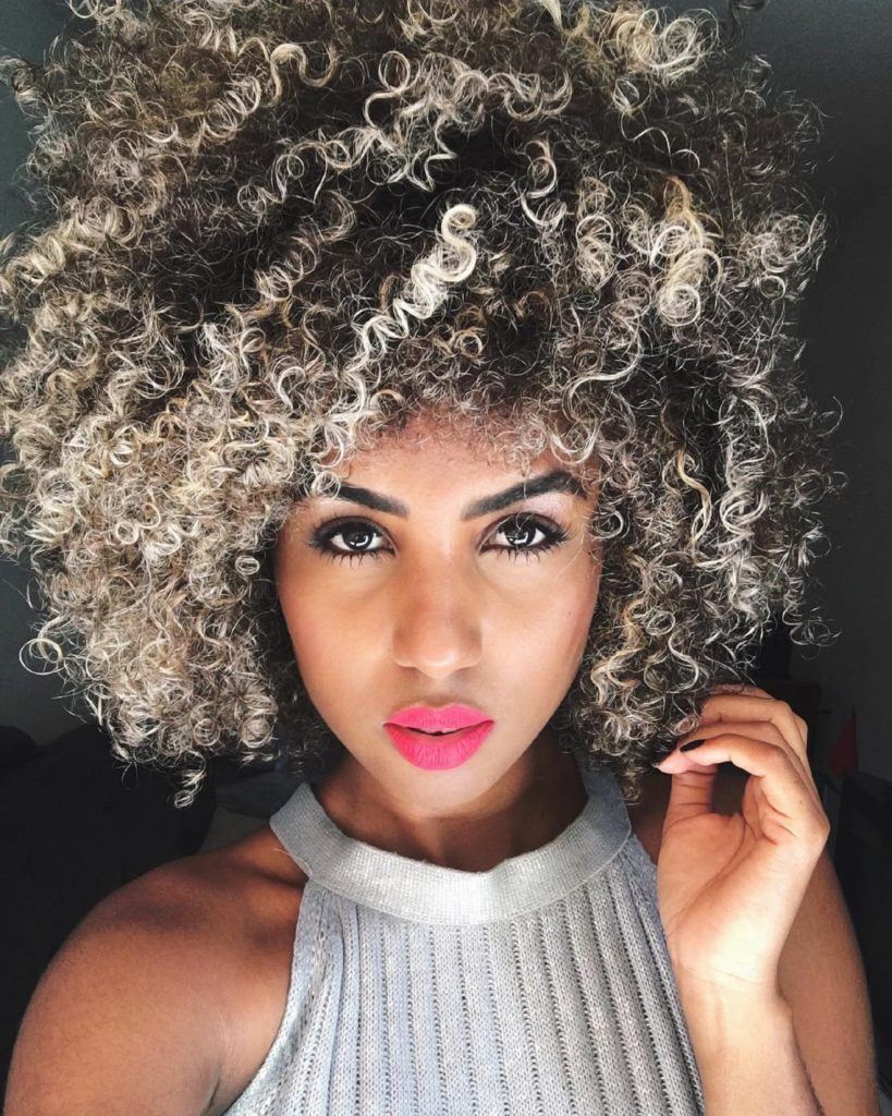 Mulher com cabelo afro e pontas platinadas