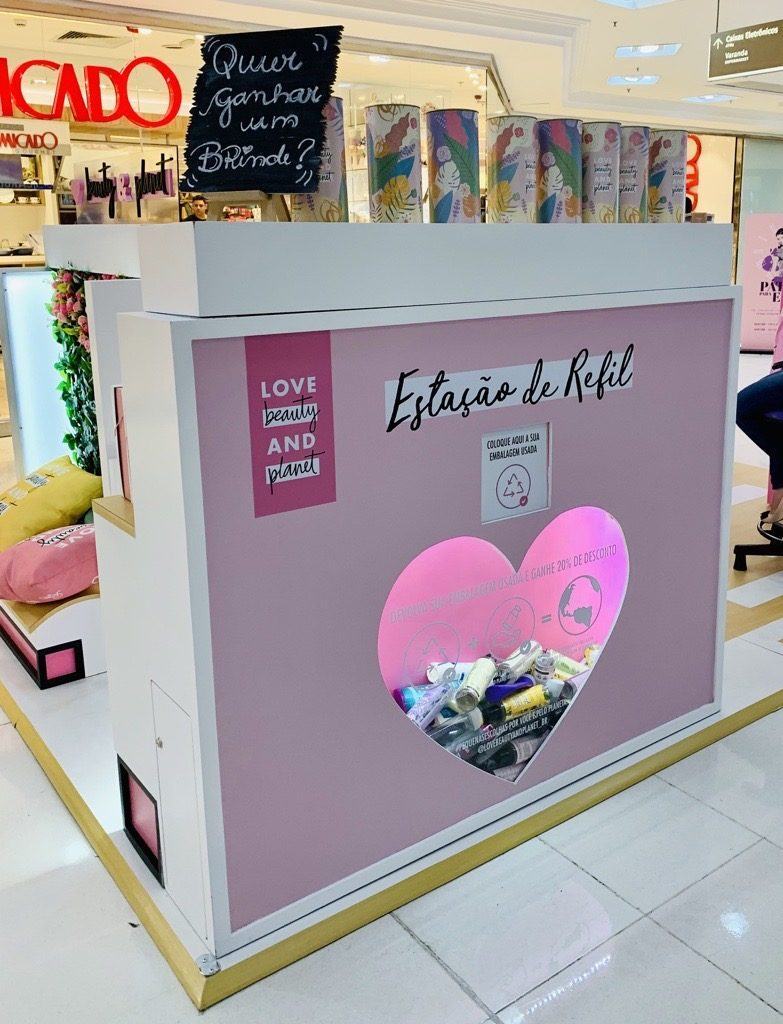 quiosque com recipientes para serem reciclados e refil de garrafas de shampoo