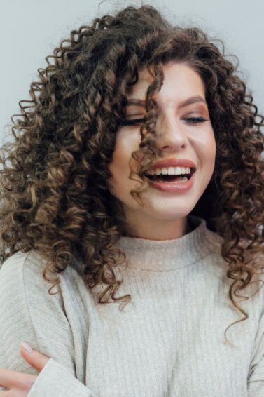 mulher com cabelo cacheado sorrindo