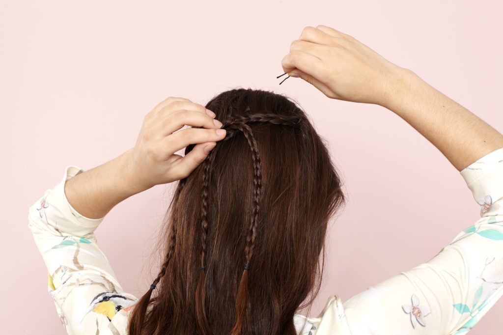 Modelo ensina o quinto passo do semipreso boho com três tranças