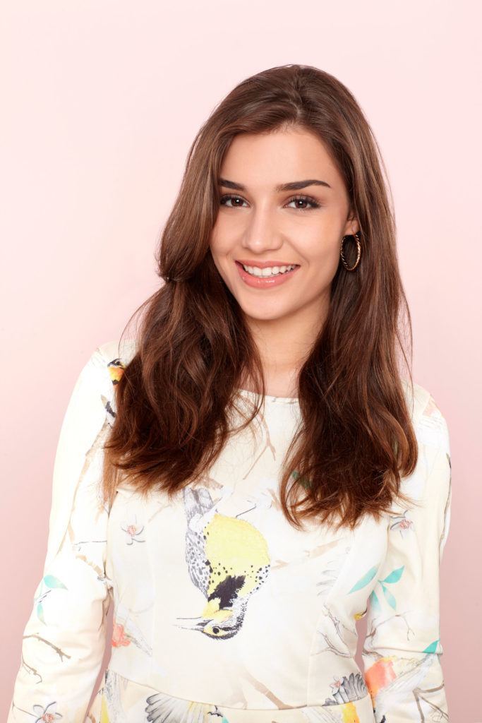 mulher com cabelo longo e liso, prestes a ensinar como fazer o semipreso boho com três tranças
