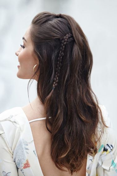 Modelo exibe o penteado pronto, semipreso boho com três tranças