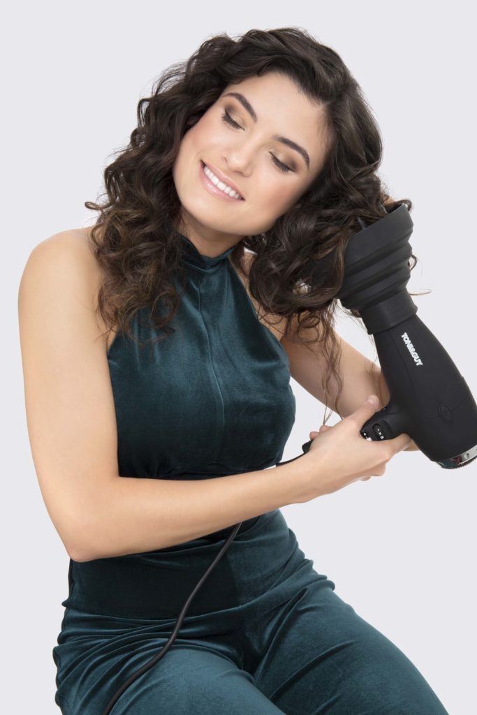 modelo ilustrando matéria sobre cachear cabelo ondulado com secador