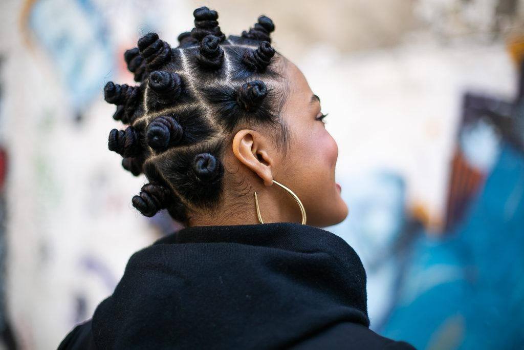 Modelo com cabelos crespos e penteado bantu knots