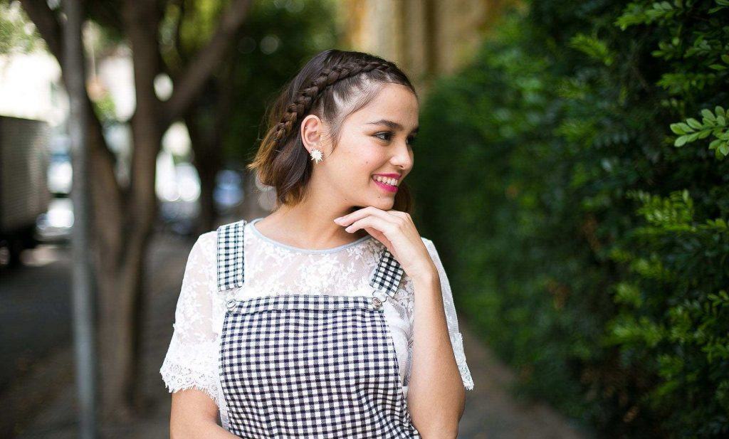 Modelo com cabelo médio e penteado com trança na franja