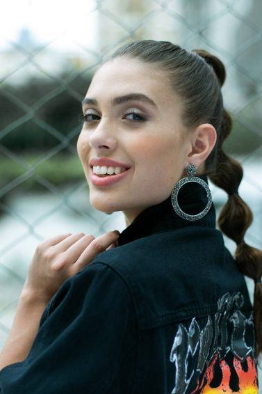 Modelo com cabelos castanhos e longos com penteado rabo de cavalo bolha para o Coala Festival
