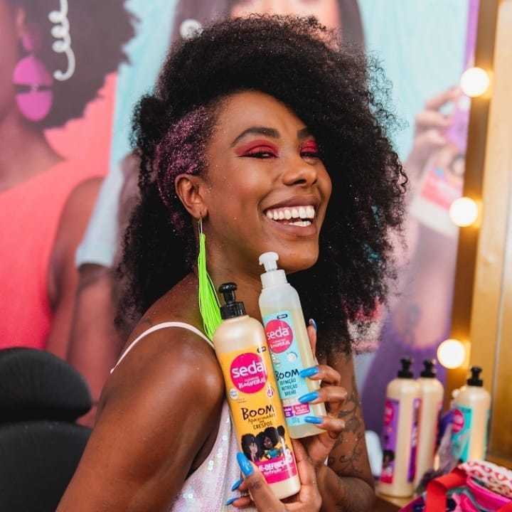 Influenciadora Xan Ravelli segura os produtos Creme de Pentear Seda Boom Apaixonadas por Crespos e Óleo em Gel Seda Boom