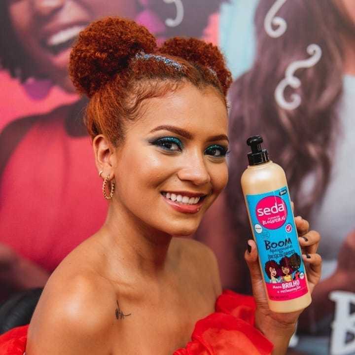 Influenciadora Julia Lira segura o Creme de Pentear Seda Boom Apaixonadas por [Des]Coloridos