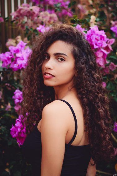 mulher com cabelo cacheado longo de lado