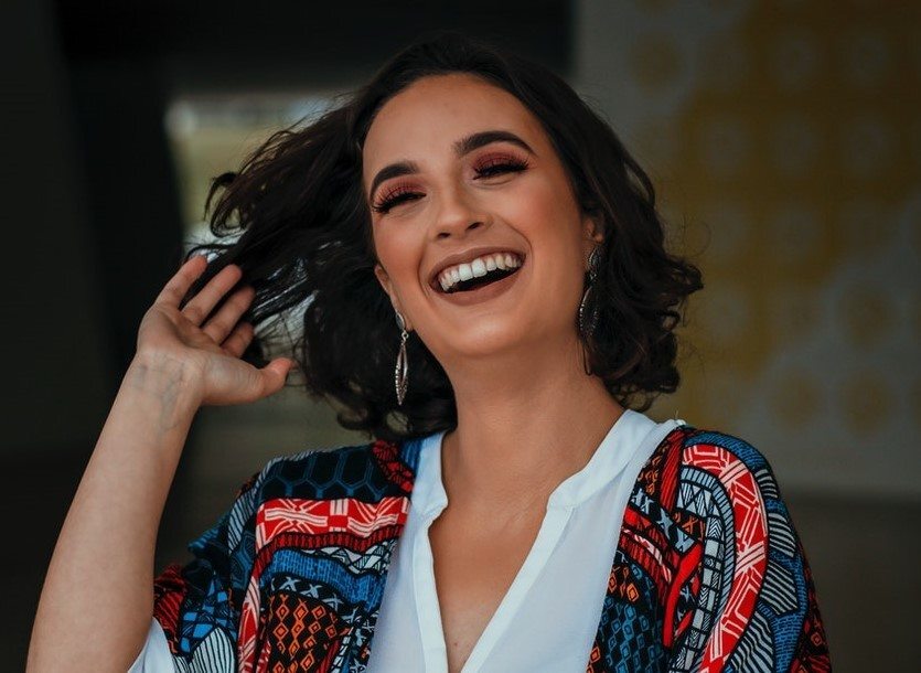 Mulher de cabelo preto curto que usa produtos para cabelos ondulados
