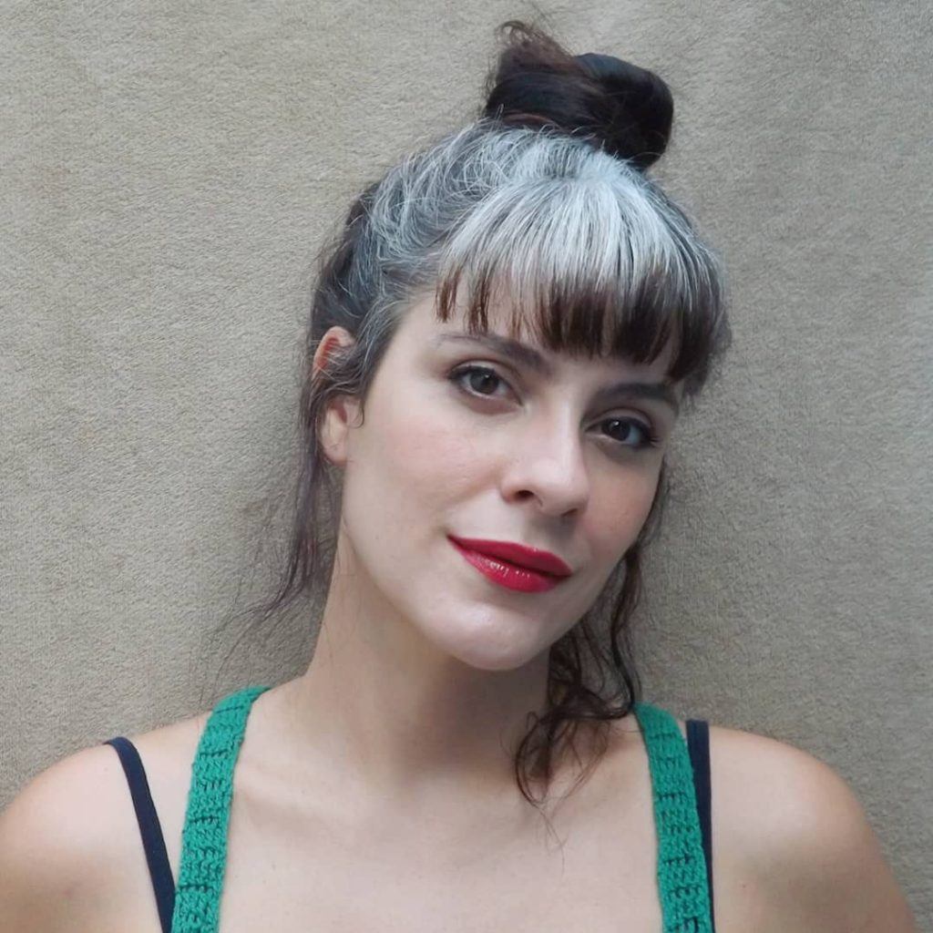 mulher com cabelo branco, coque e franja