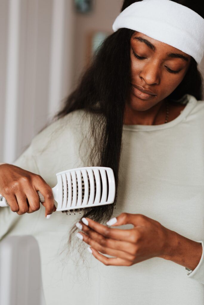 mulher desembaraçando cabelo com escova