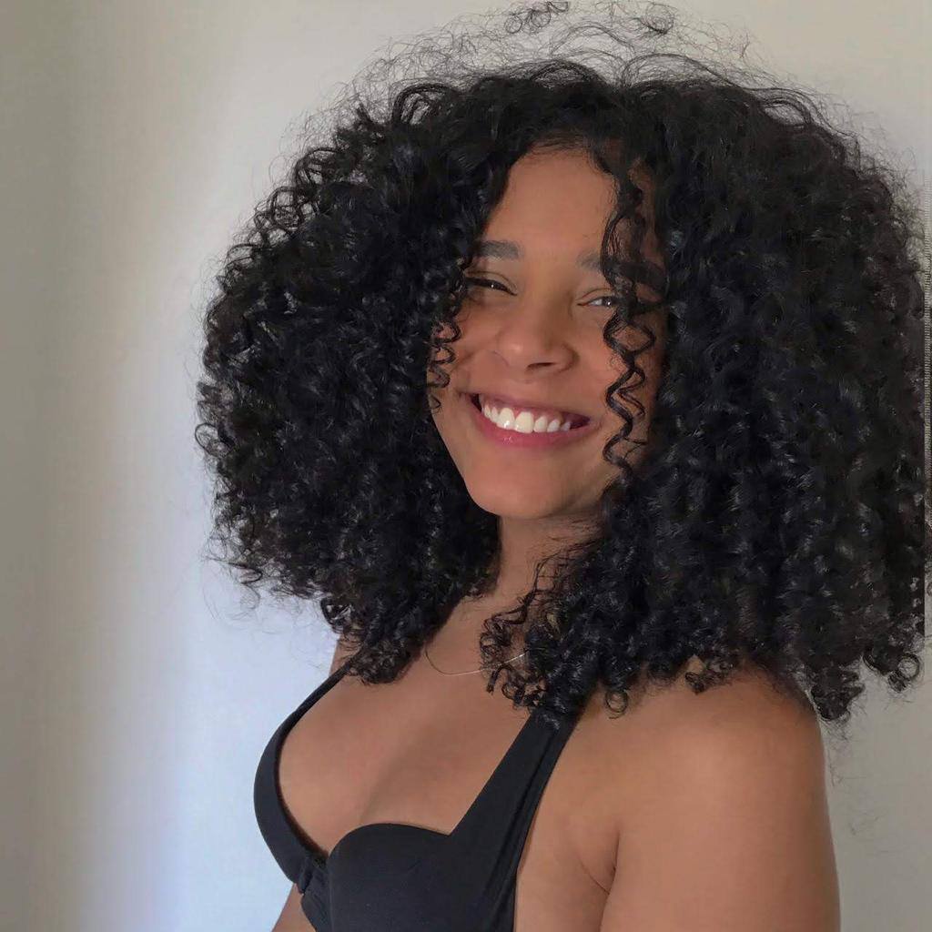 mulher com cabelo cacheado sorrindo