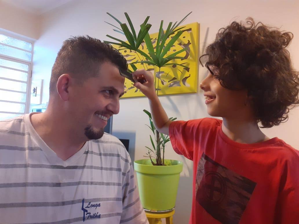 Foto de Ian penteando o cabelo do pai, Anderson, após o corte