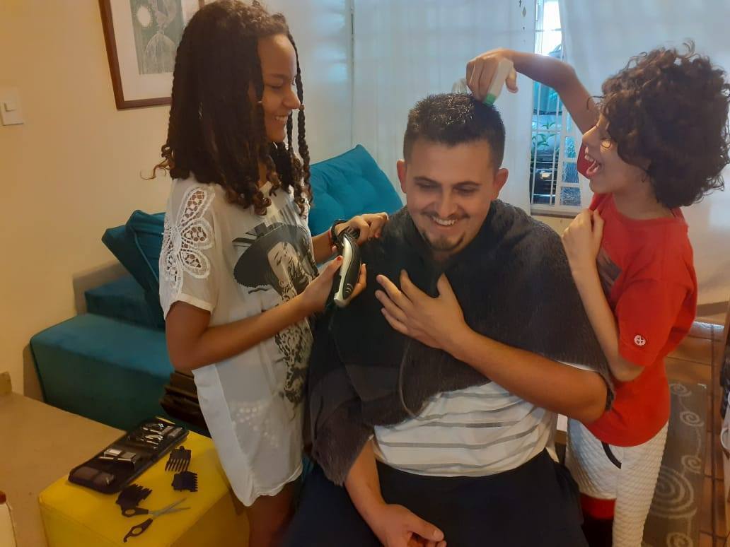 Os filhos Ian e Vitória preparam o cabelo do pai Anderson para o corte