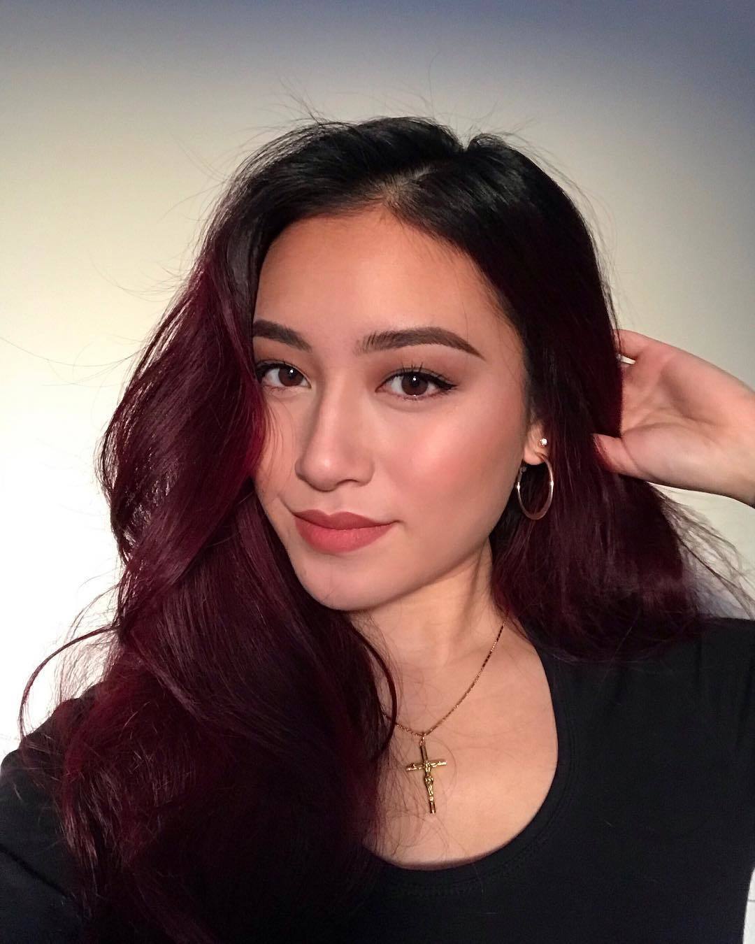 Mulher com luzes avermelhadas no cabelo longo e liso
