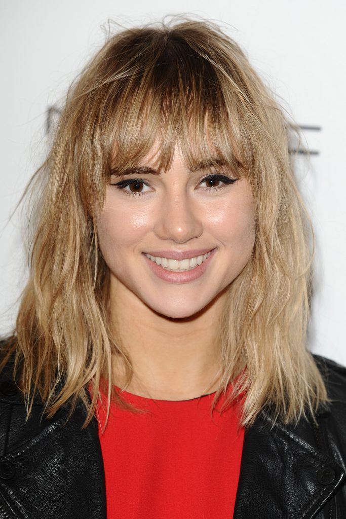 mulher com cabelo médio loiro e franja na sobrancelha