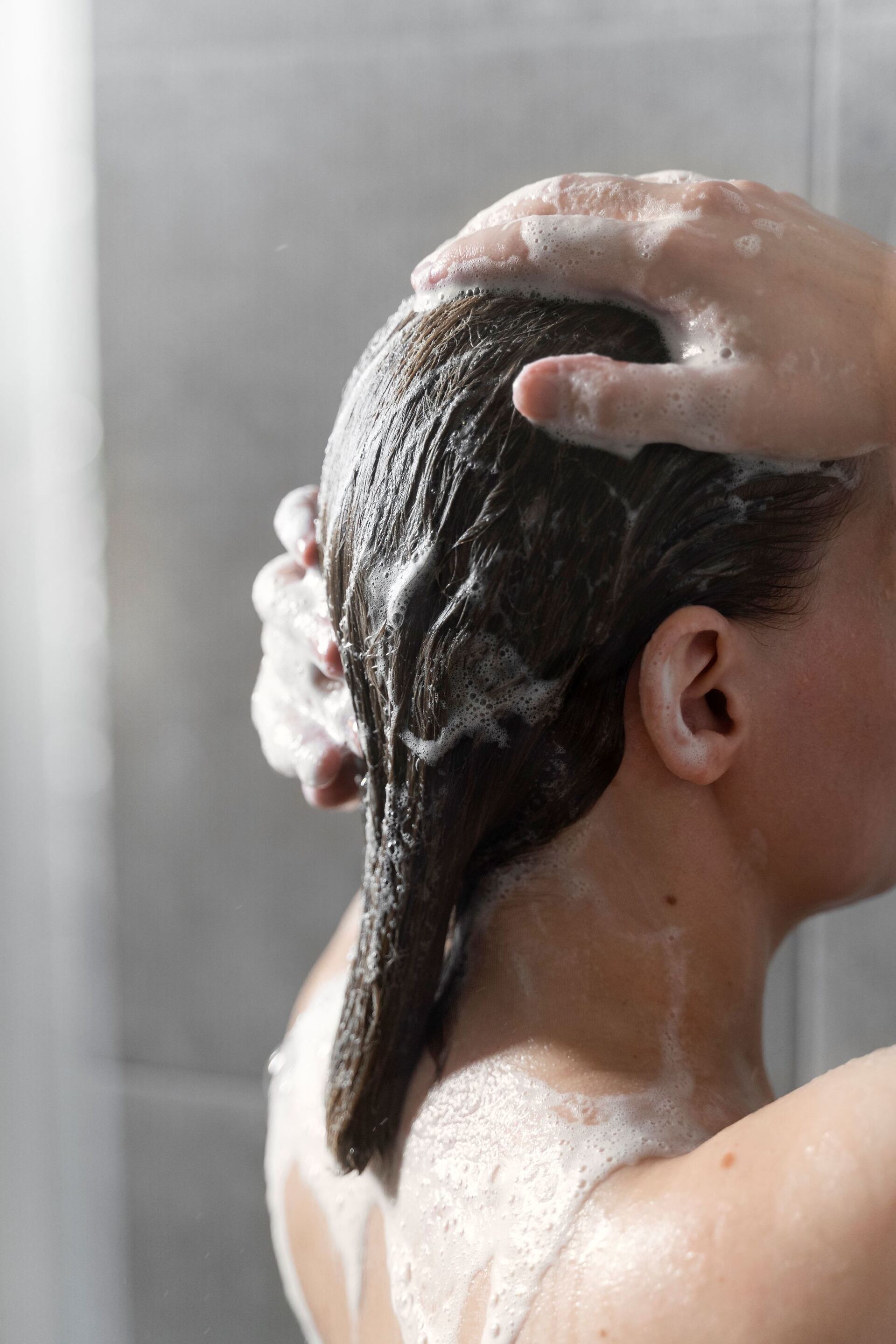 mulher lavando o cabelo com couro cabeludo oleoso