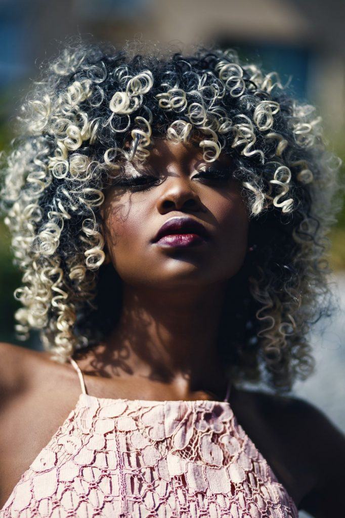 Garota de cabelo cacheado com luzes platinadas
