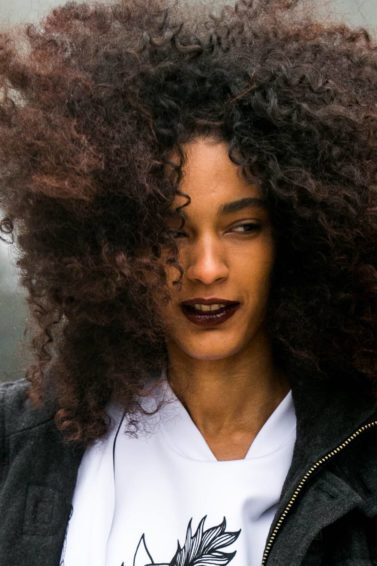 Por que o cabelo embaraça? Mulher com o cabelo ao vento ilustra a matéria sobre o assunto
