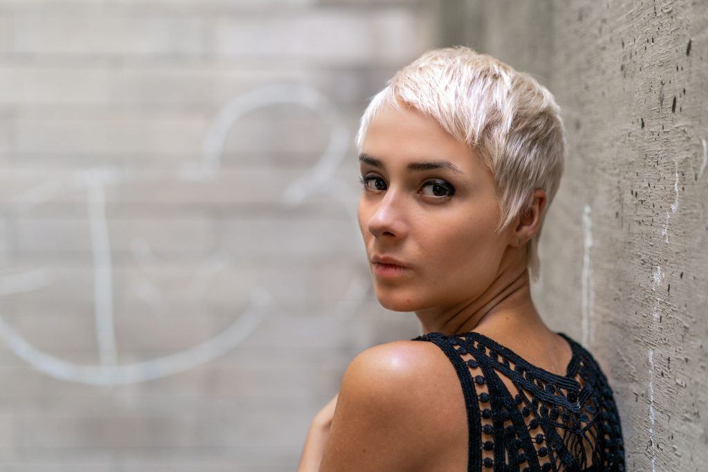 mulher com cabelo platinado pixie cut liso