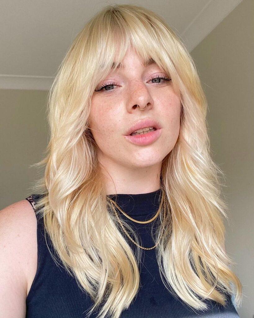 Mulher loira com franja da moda wolf bangs anos 80