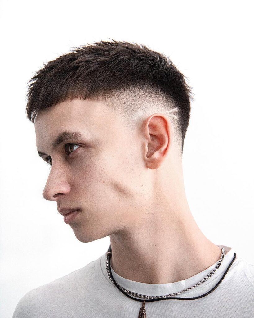 menino olhando para o lado com lateral do cabelo raspada