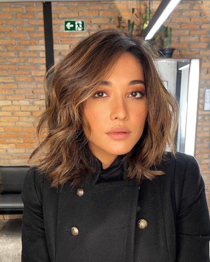 mulher de jaqueta preta com chanel e franja lateral