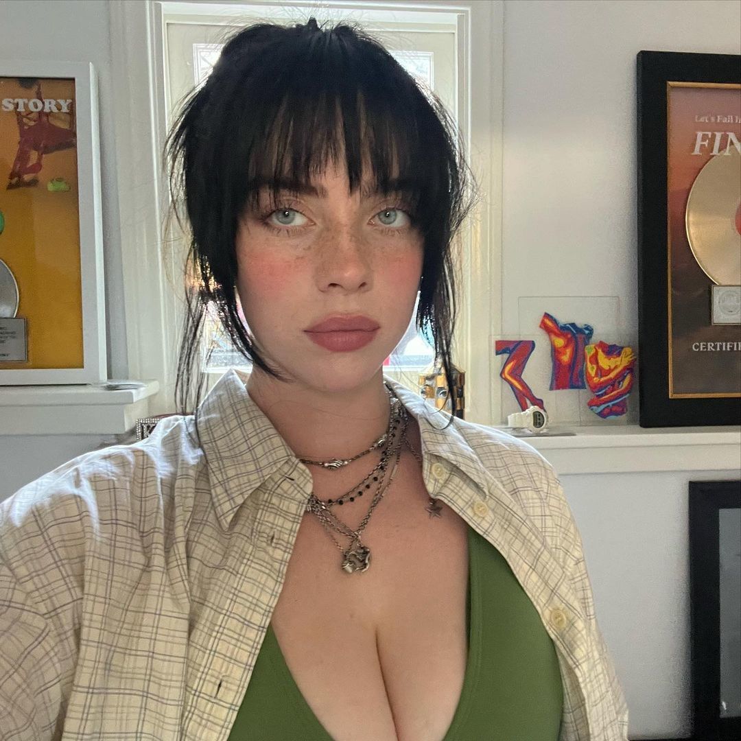 Billie Eilish com cabelos presos e franja desfiada