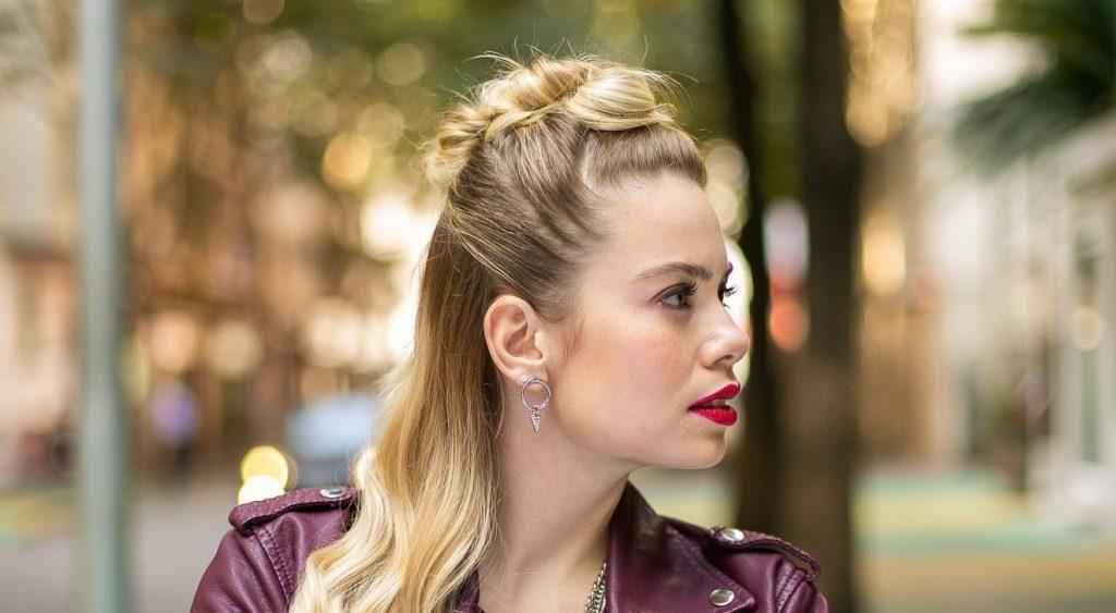 Modelo com cabelos loiros e penteado semipreso com moicano