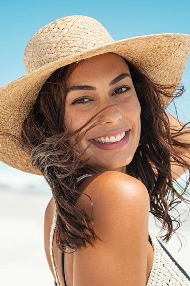 mulher com cabelo no verão com chapeu